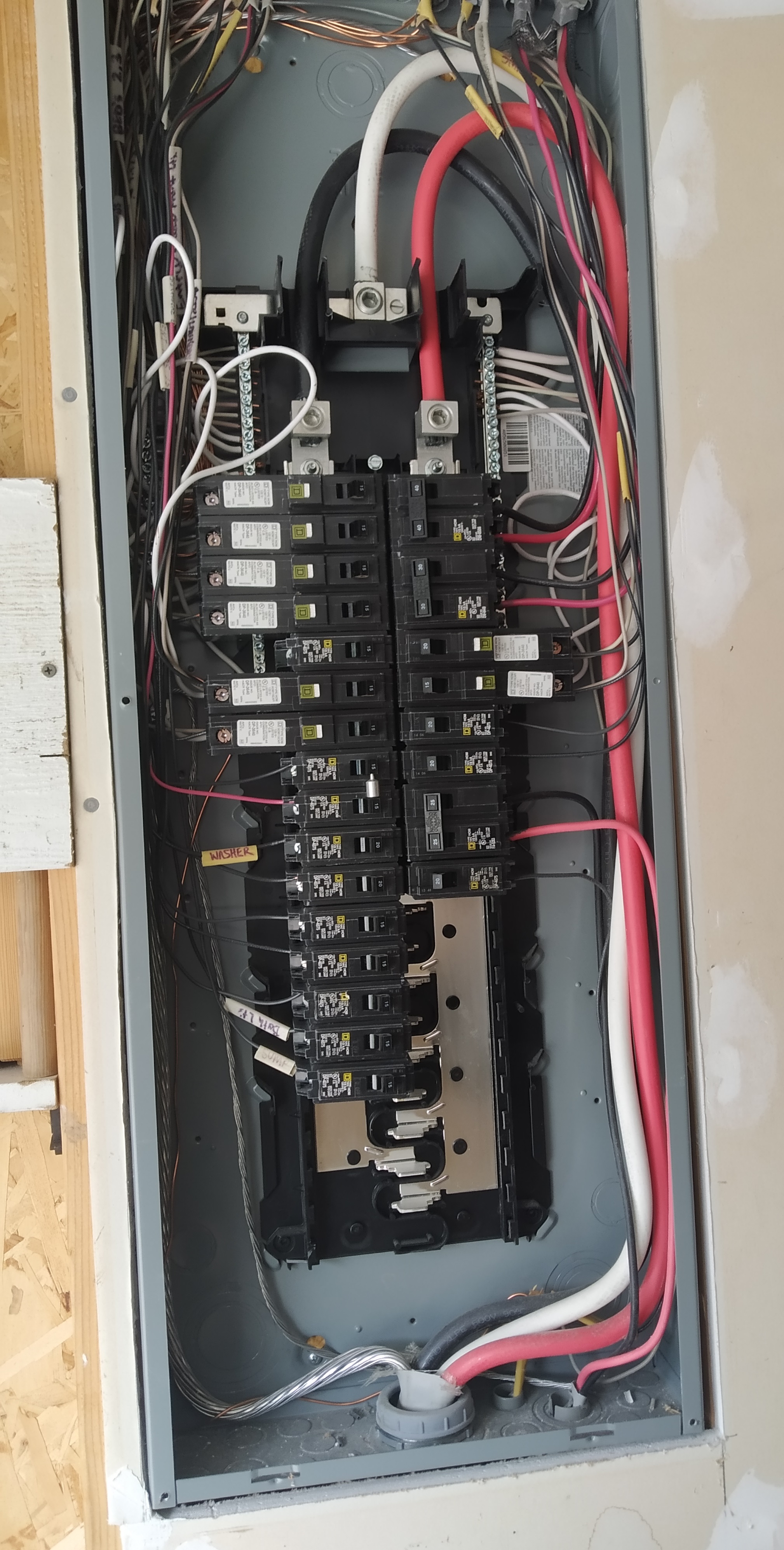 The electrical panel with three main lines entering from the bottom of the panel and snaking to the top.